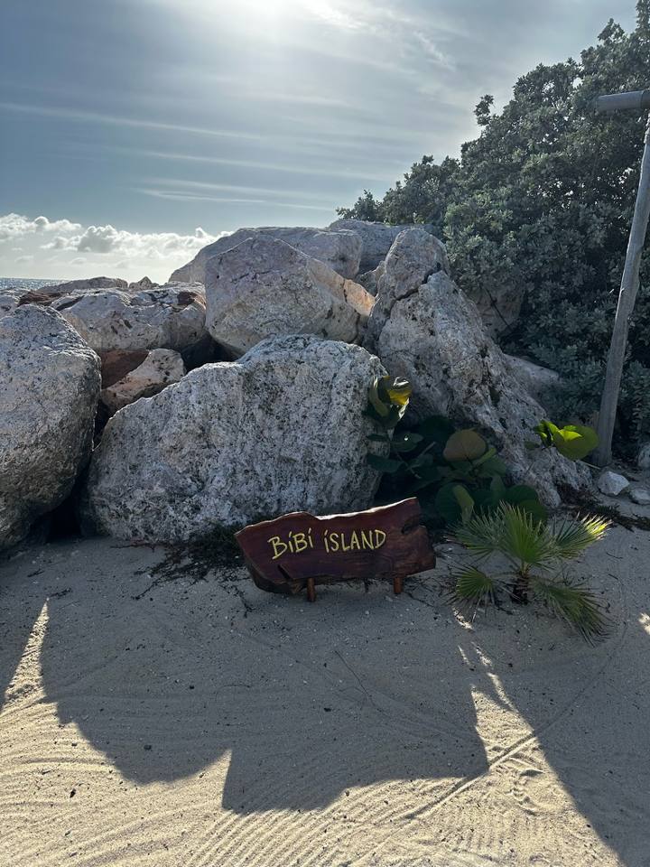 A Bibi Island sign on a quiet beach at Baoase