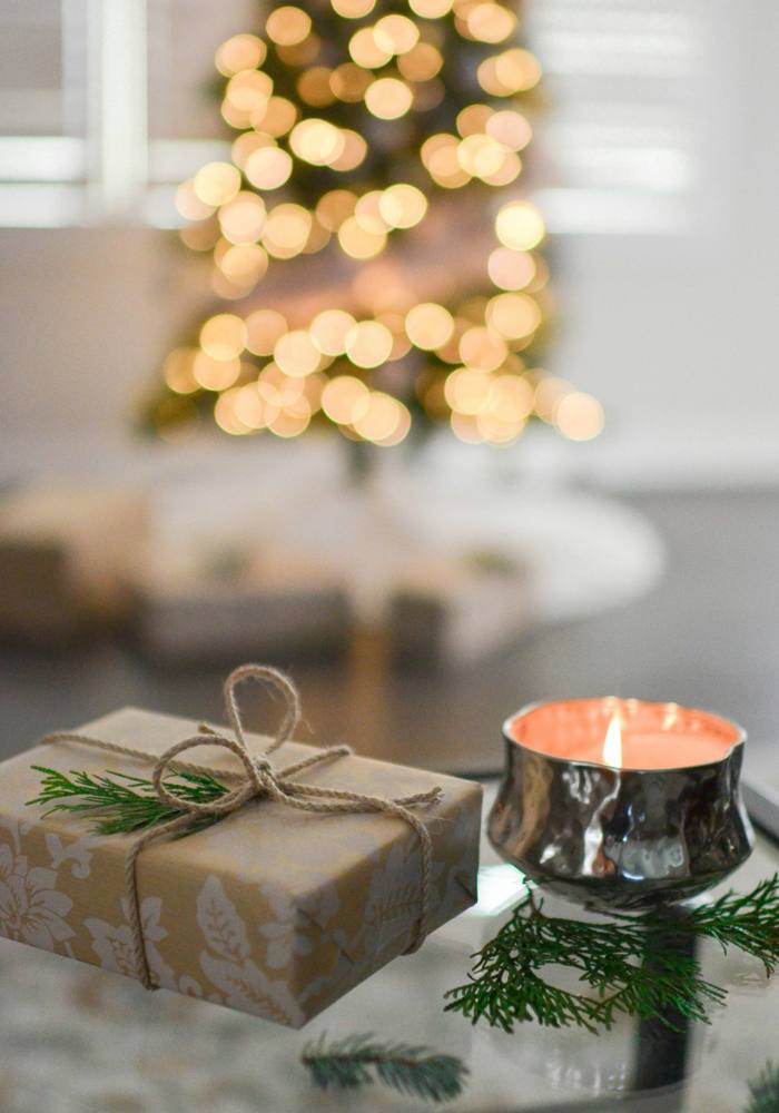 A gift wrapped in kraft paper next to a candle