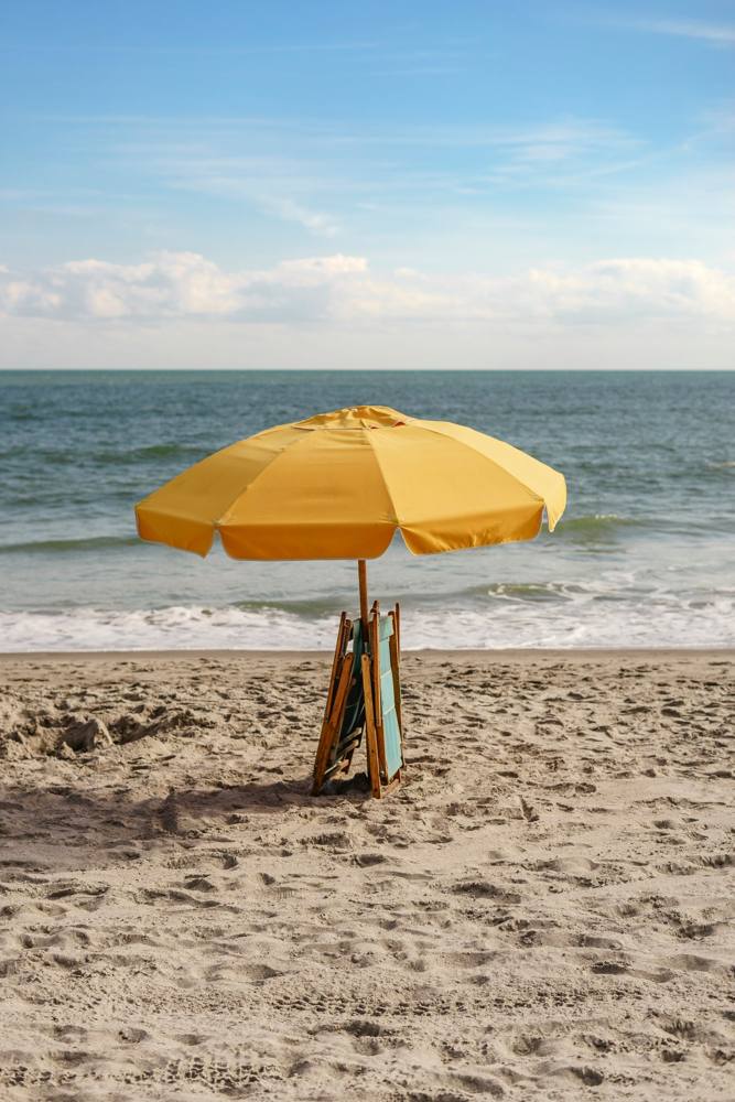 A yellow beach umbrella on the sand