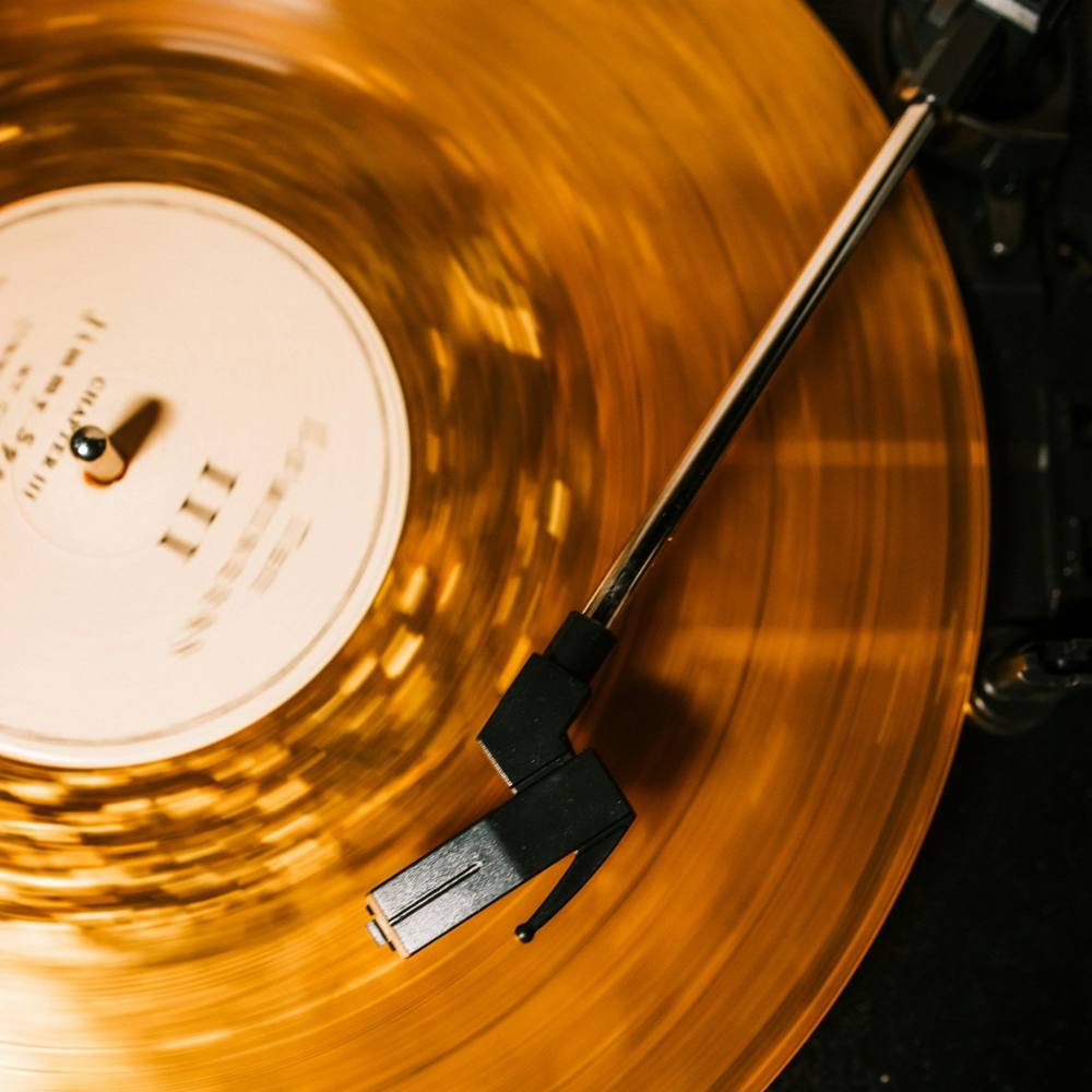 A gold vinyl record spinning on a turntable