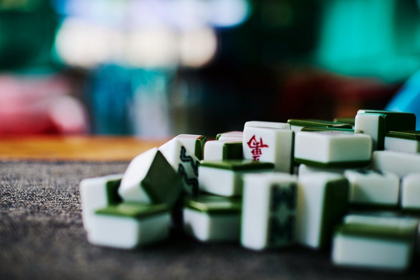 A pile of white and green mahjong tiles on a table
