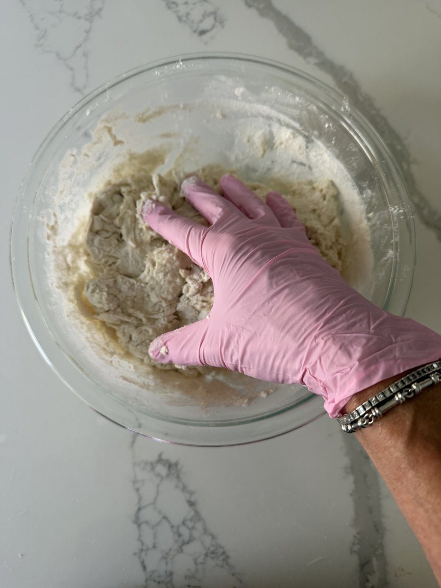 Gloved hands shaping dough